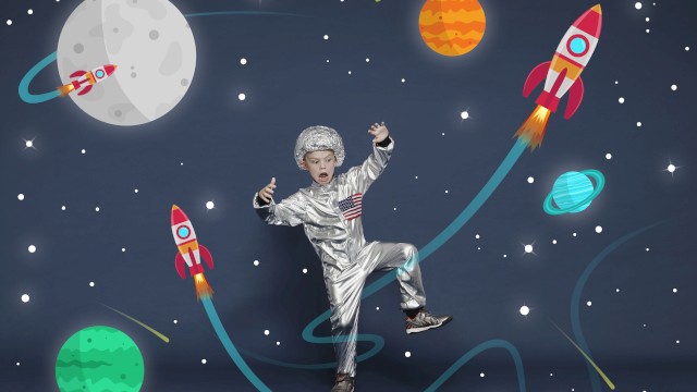 A child in a spacesuit poses against a space-themed background with rockets, planets, and stars, appearing to float in space.