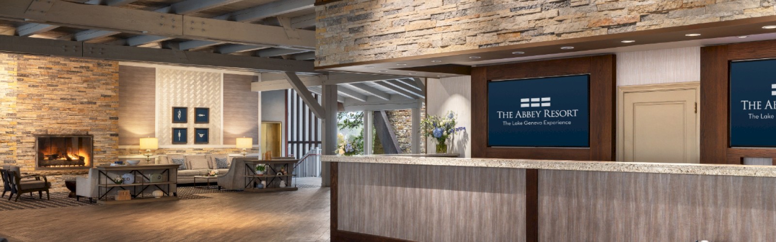 The image shows a modern hotel lobby with a reception desk, cozy seating area, and a fireplace, featuring warm lighting and contemporary decor.