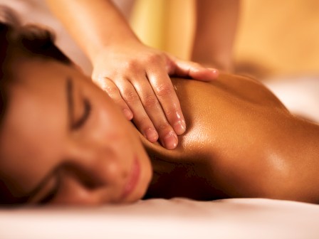 A person receiving a massage on their back, with a focus on a relaxing spa or wellness treatment.