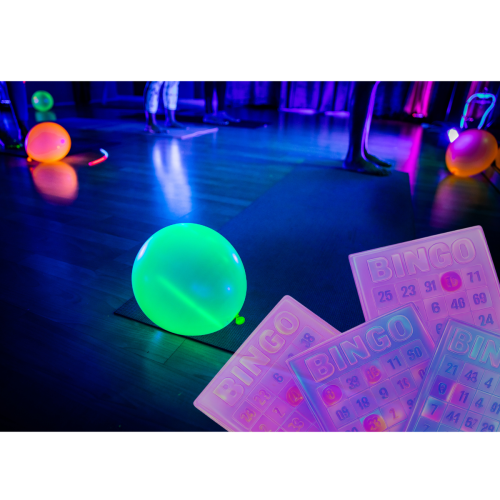 The image shows glowing balloons, bingo cards, and an illuminated scene likely from a glow-themed event or party.