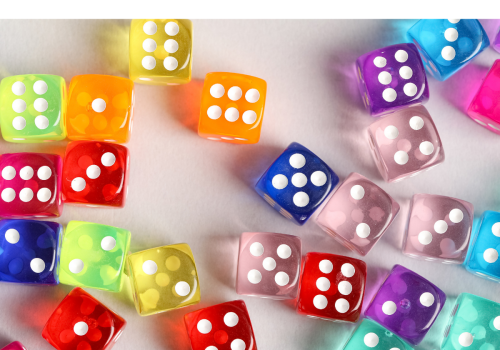 Colorful dice scattered on a white surface, with some showing four and three dots, in vibrant yellow, orange, red, purple, blue, pink, and green.