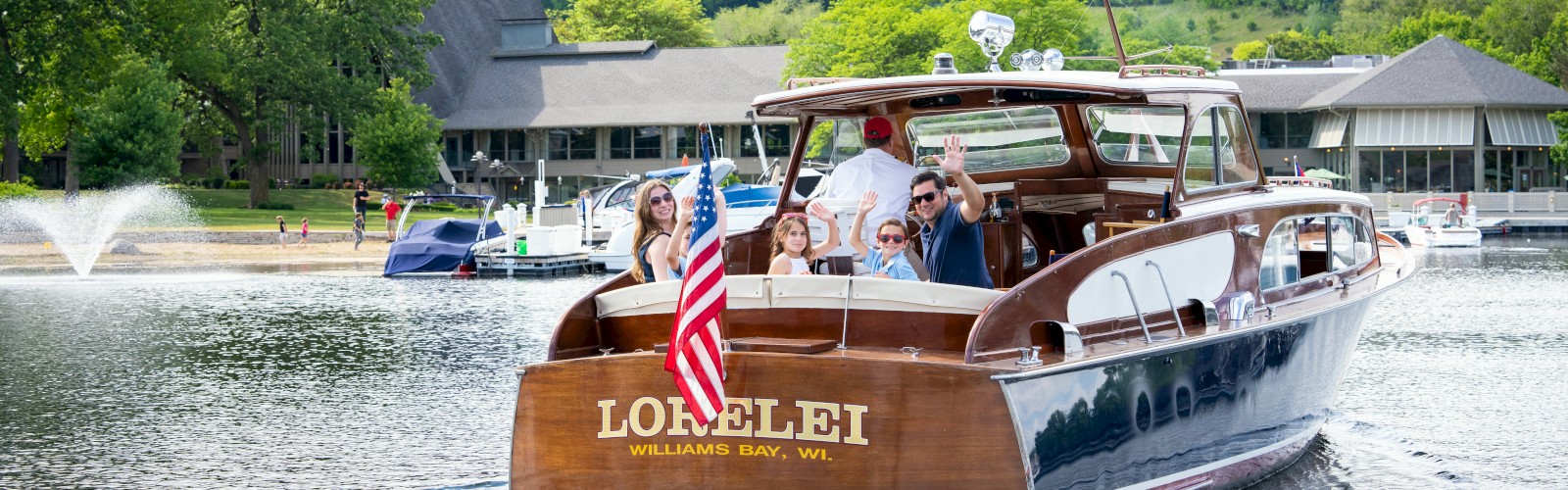 A wooden boat with a U.S. flag, named 