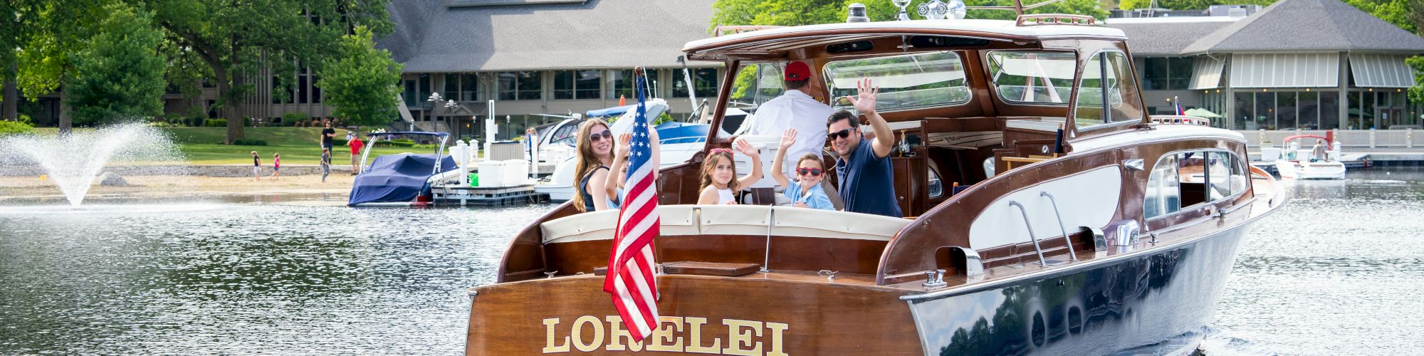 A wooden boat with a U.S. flag, named 