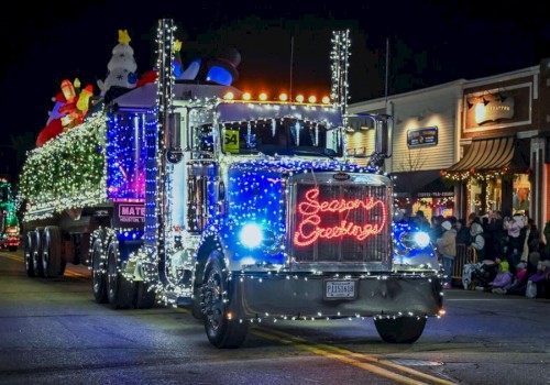 A decorated Christmas parade truck with lights and a 