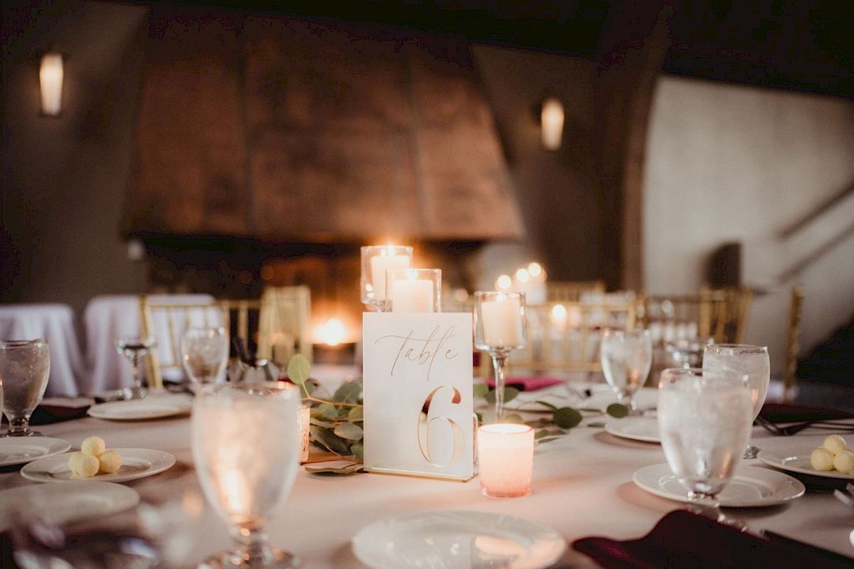 A beautifully set table with candles, glassware, plates, and a 